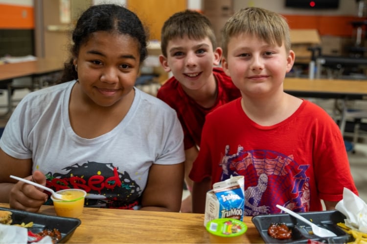 niños sentados a la mesa en una cafetería