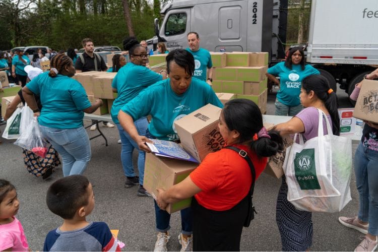 Un grupo de personas llenando y transportando cajas en un evento