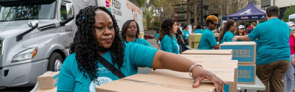 Voluntarios transportando cajas en un acto
