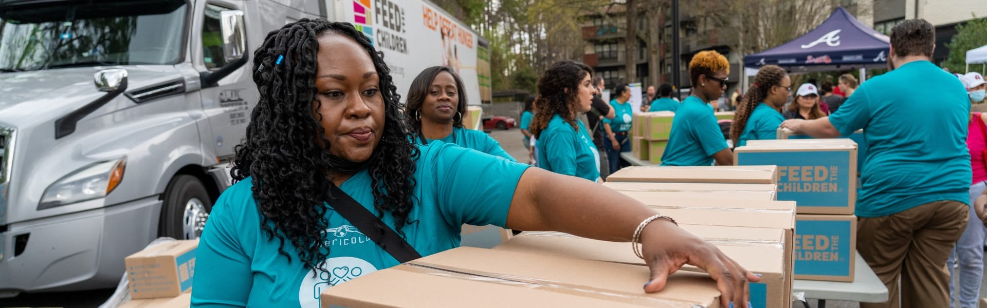 Voluntarios transportando cajas en un acto