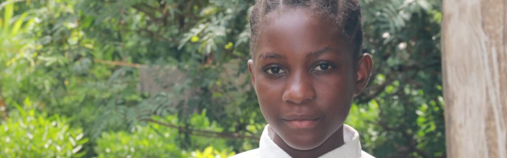 un niño al aire libre cerca de árboles y arbustos