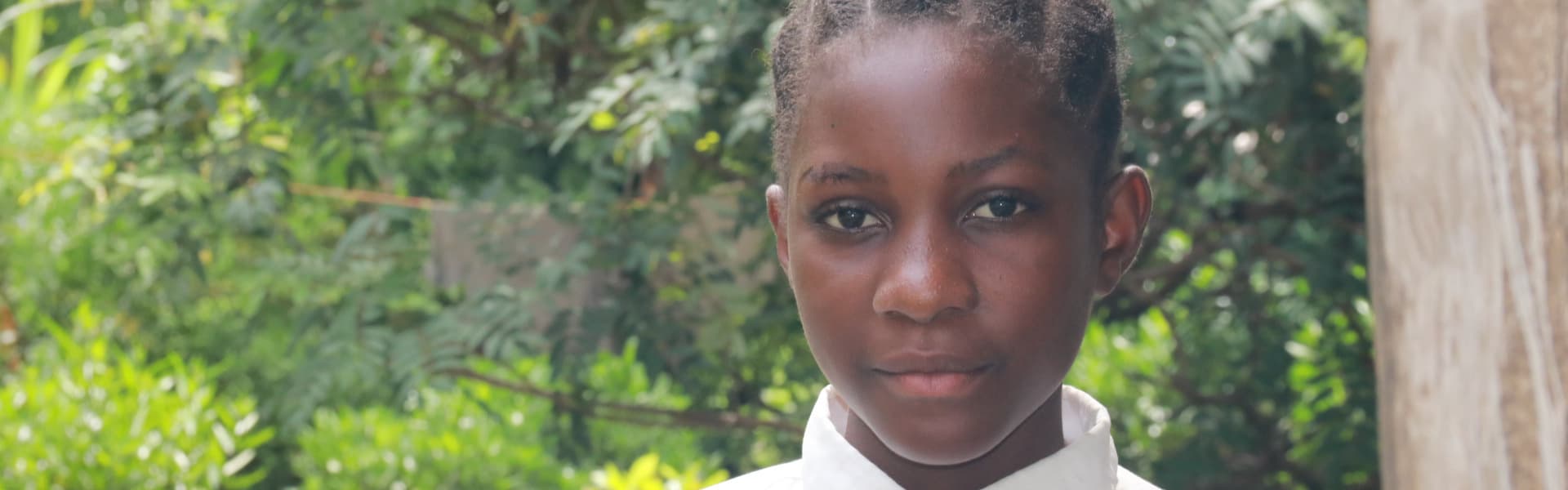 un niño al aire libre cerca de árboles y arbustos