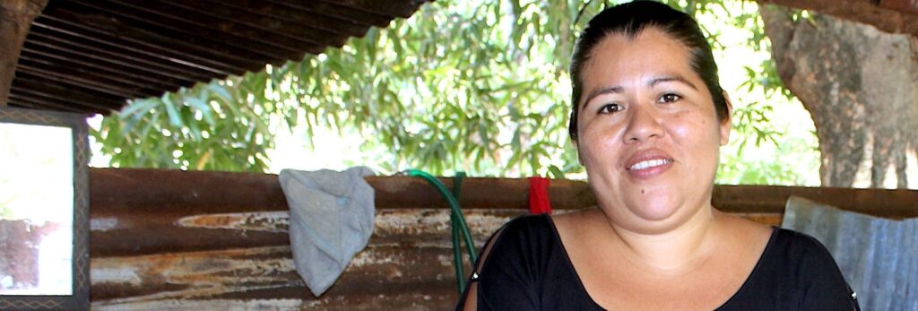 A woman smiling sitting in an outdoor structure