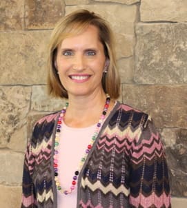 Retrato de una mujer delante de un muro de piedra