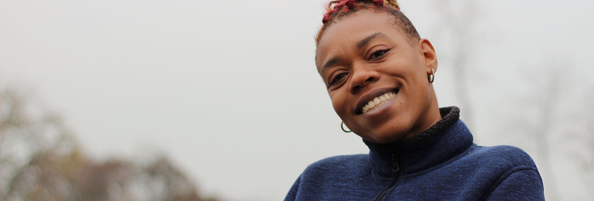 A woman smiling while standing outdoors