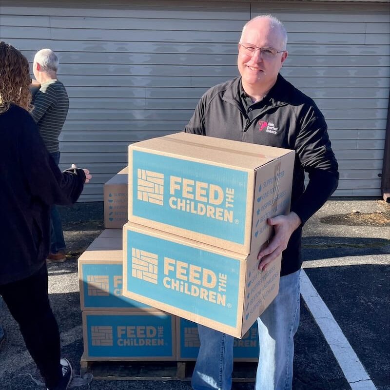 A man holding boxes full of supplies at an event