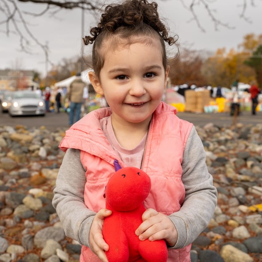 Un niño sostiene un peluche al aire libre en un evento