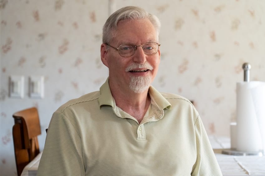 Un hombre sentado a una mesa en el interior