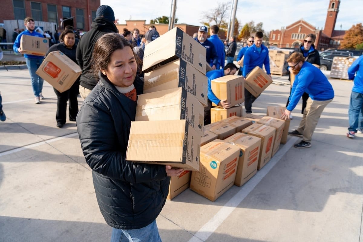 Una mujer reparte cajas en un acto