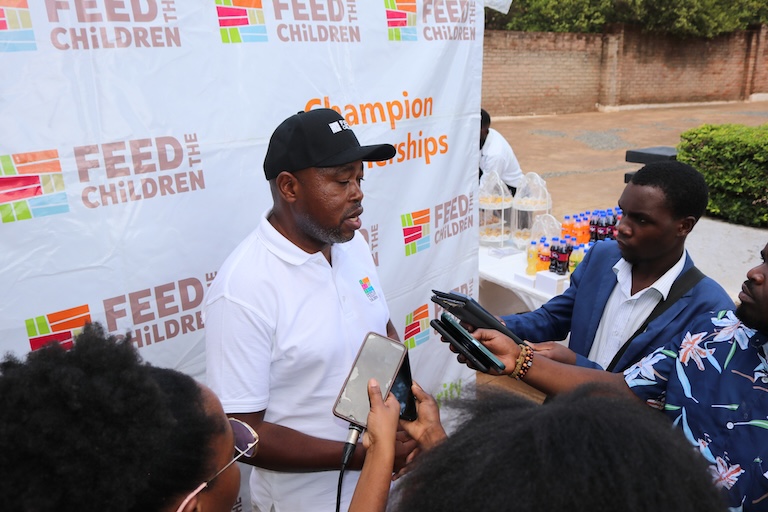 Un hombre siendo entrevistado al aire libre en un evento.