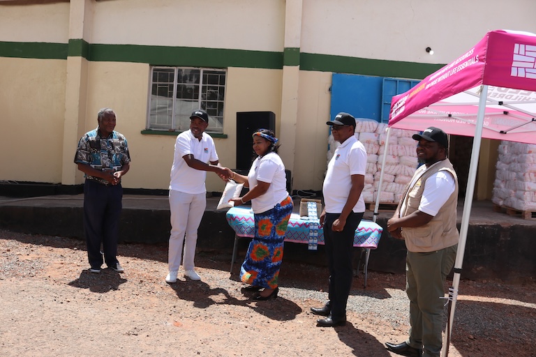 Un grupo de personas al aire libre cerca de una tienda de campaña y provisiones.