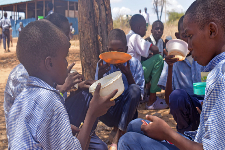Niños comiendo de tazones en África.
